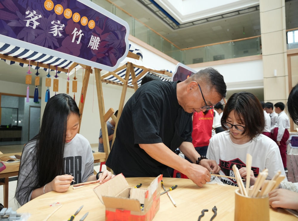 3、非遗传承人郭英雄（中）教授学生客家竹雕制作技艺